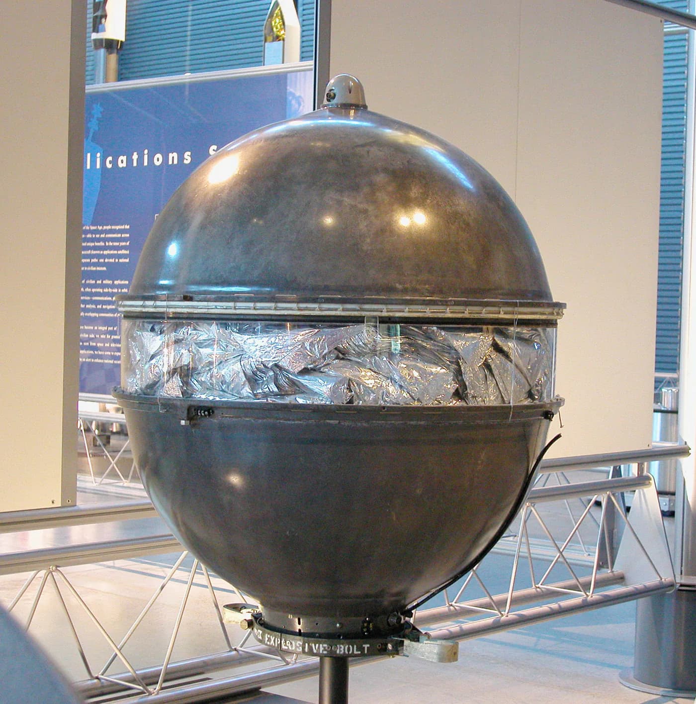 The reflective Echo 1 communications satellite is displayed in a museum setting.