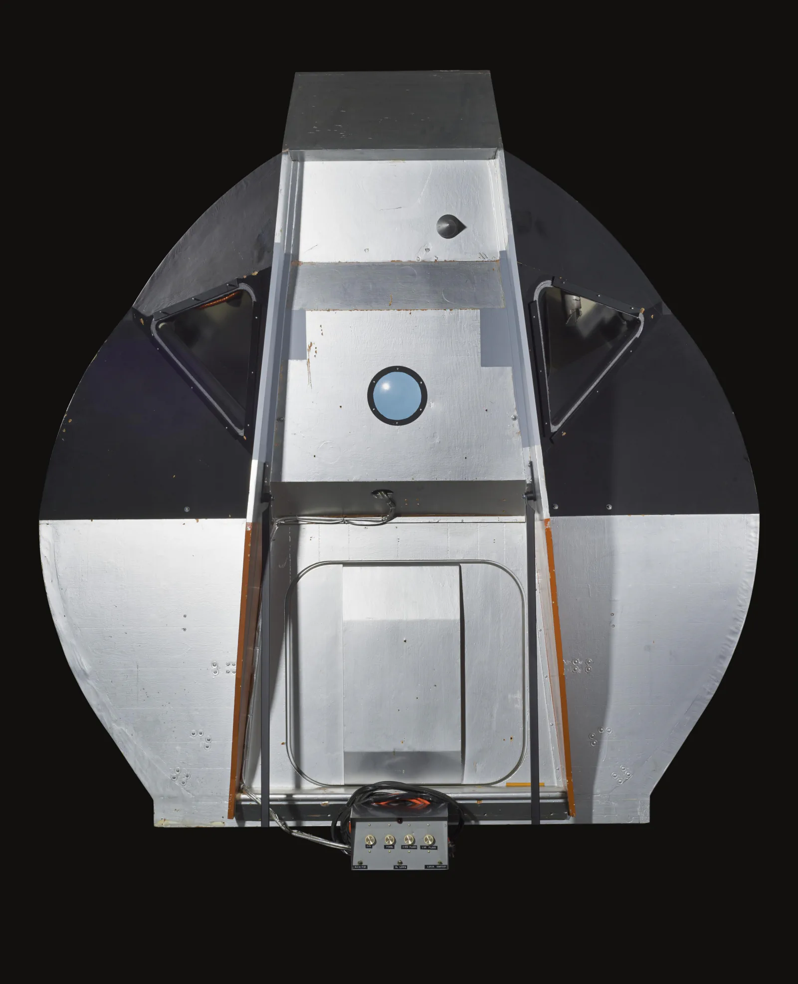 A full-scale Apollo lunar module cockpit mockup shows its controls and windows.