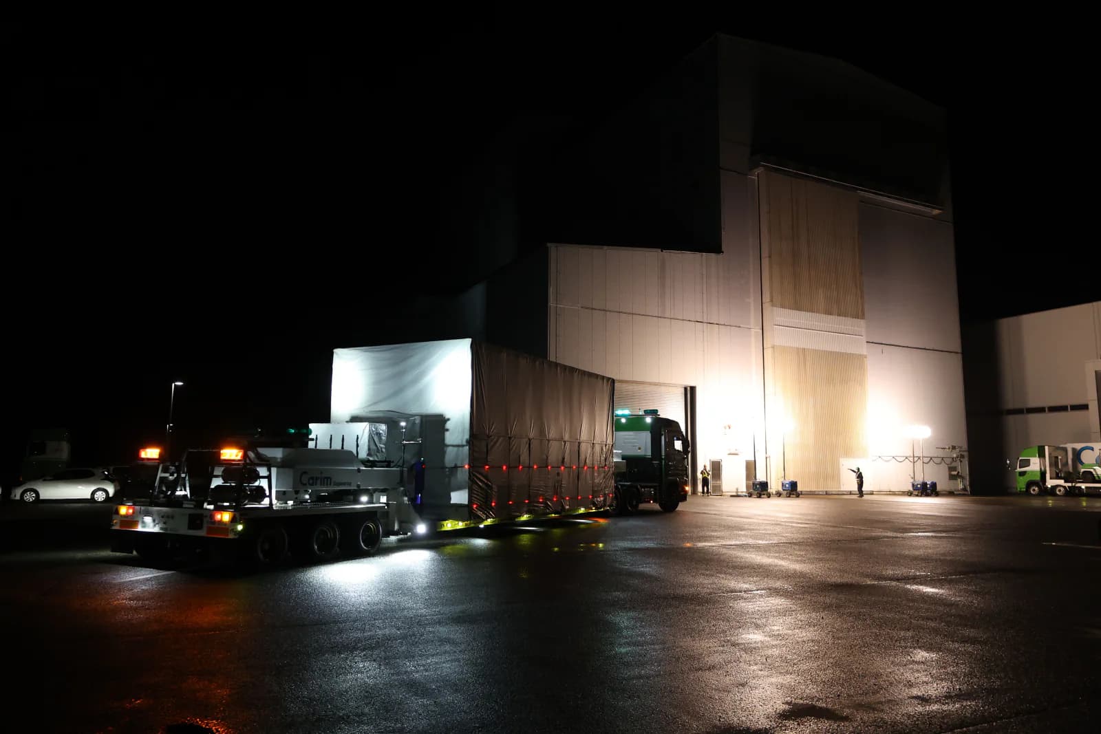 The ALOS-3 spacecraft is enclosed for transport inside a clean facility.