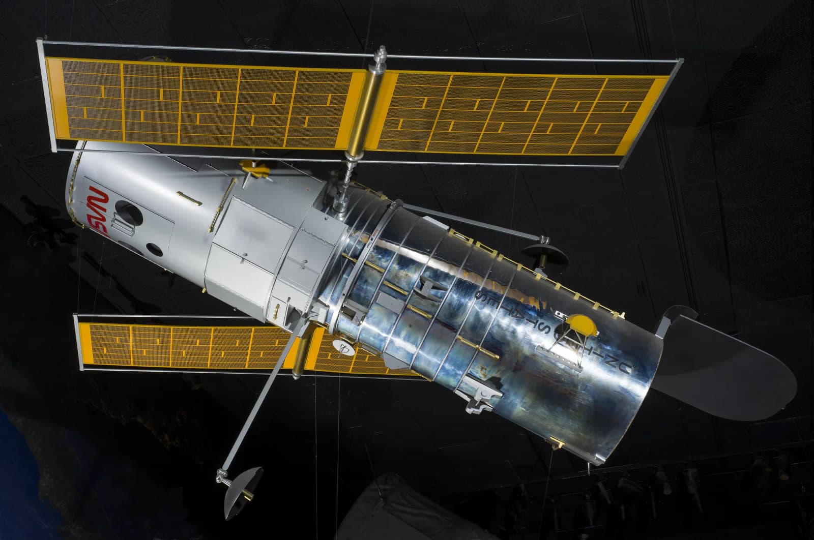 A one-fifth-scale Hubble Space Telescope model is displayed from the side.