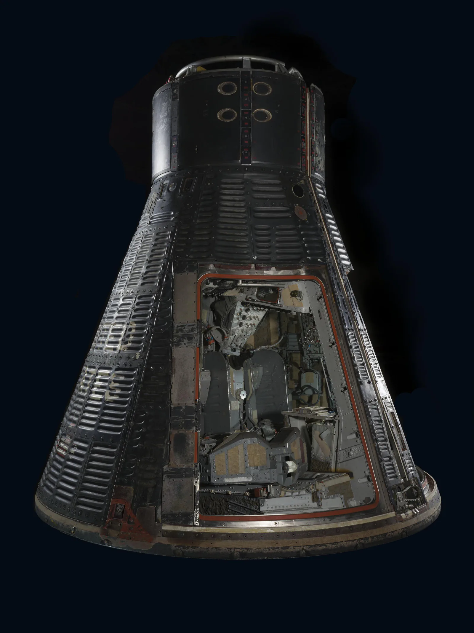 The Gemini VII capsule is displayed with its dark heat shield and open hatch visible.