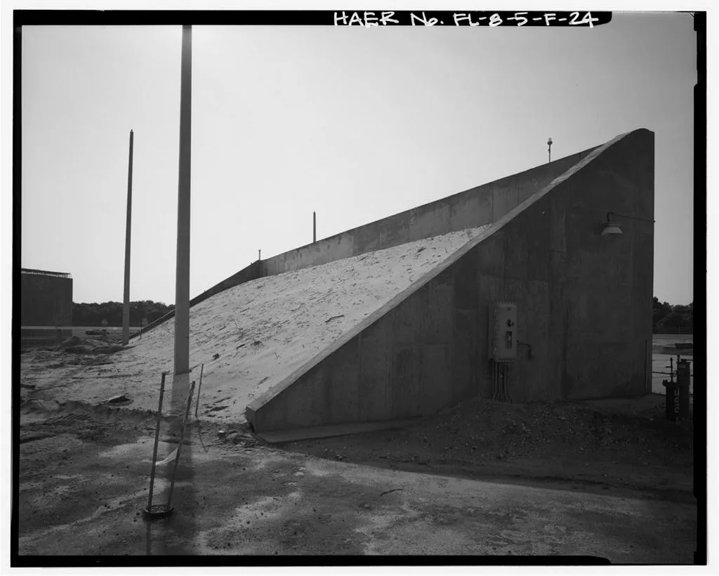 An archival photograph shows the concrete blast berm beside Launch Complex 17 infrastructure.