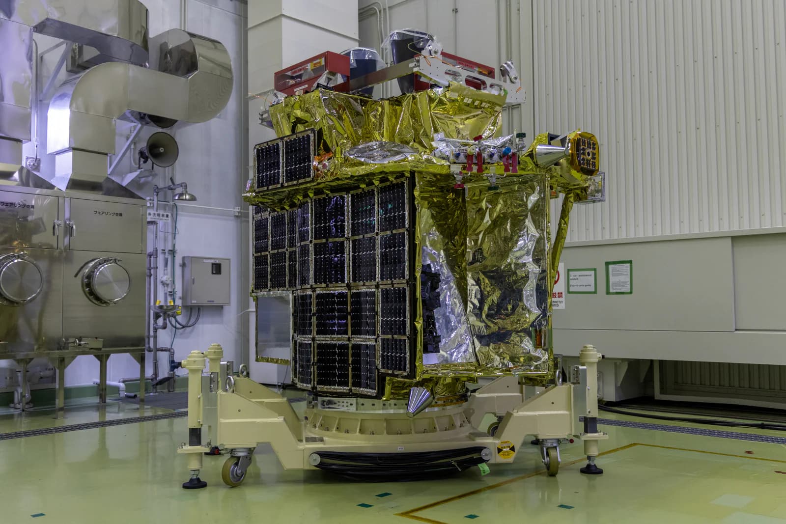 The SLIM lunar lander flight model stands inside an integration facility.